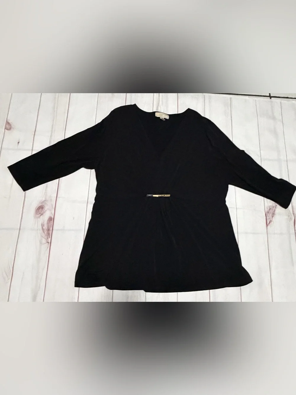 Black Michael Kors blouse with a V-neck, faux-wrap design, and gold bar at the w